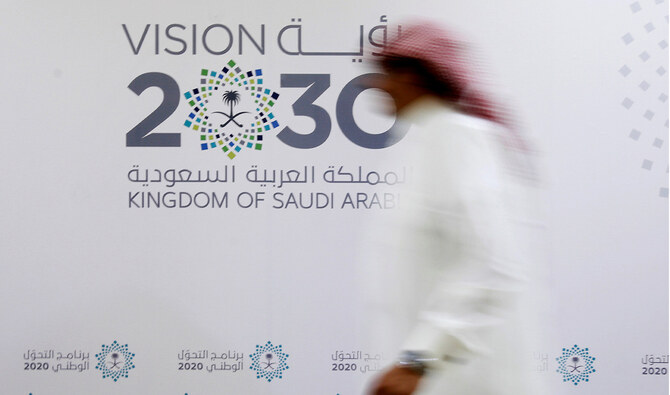 A Saudi man walks past the logo of Vision 2030 after a news conference in Jeddah, Saudi Arabia. Reuters/File