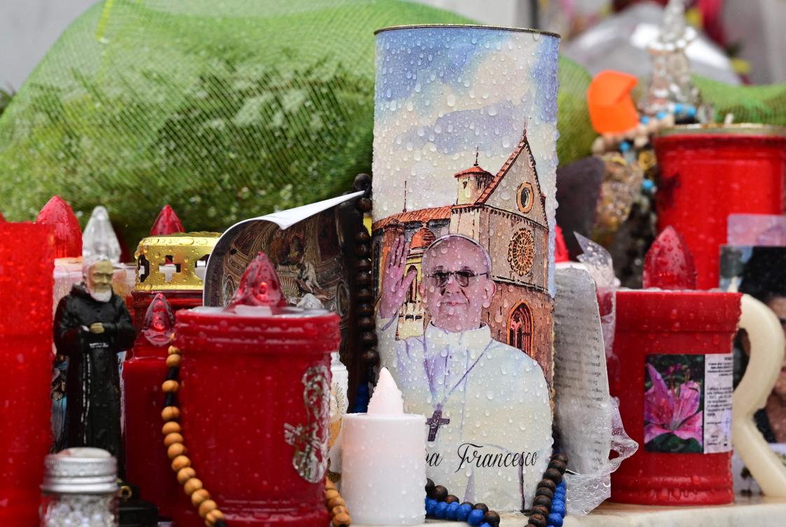Candles are laid at the statue of John Paul II outside the Gemelli hospital where Pope Francis is hospitalized with pneumonia, in Rome on Mar. 12, 2025. (AFP)