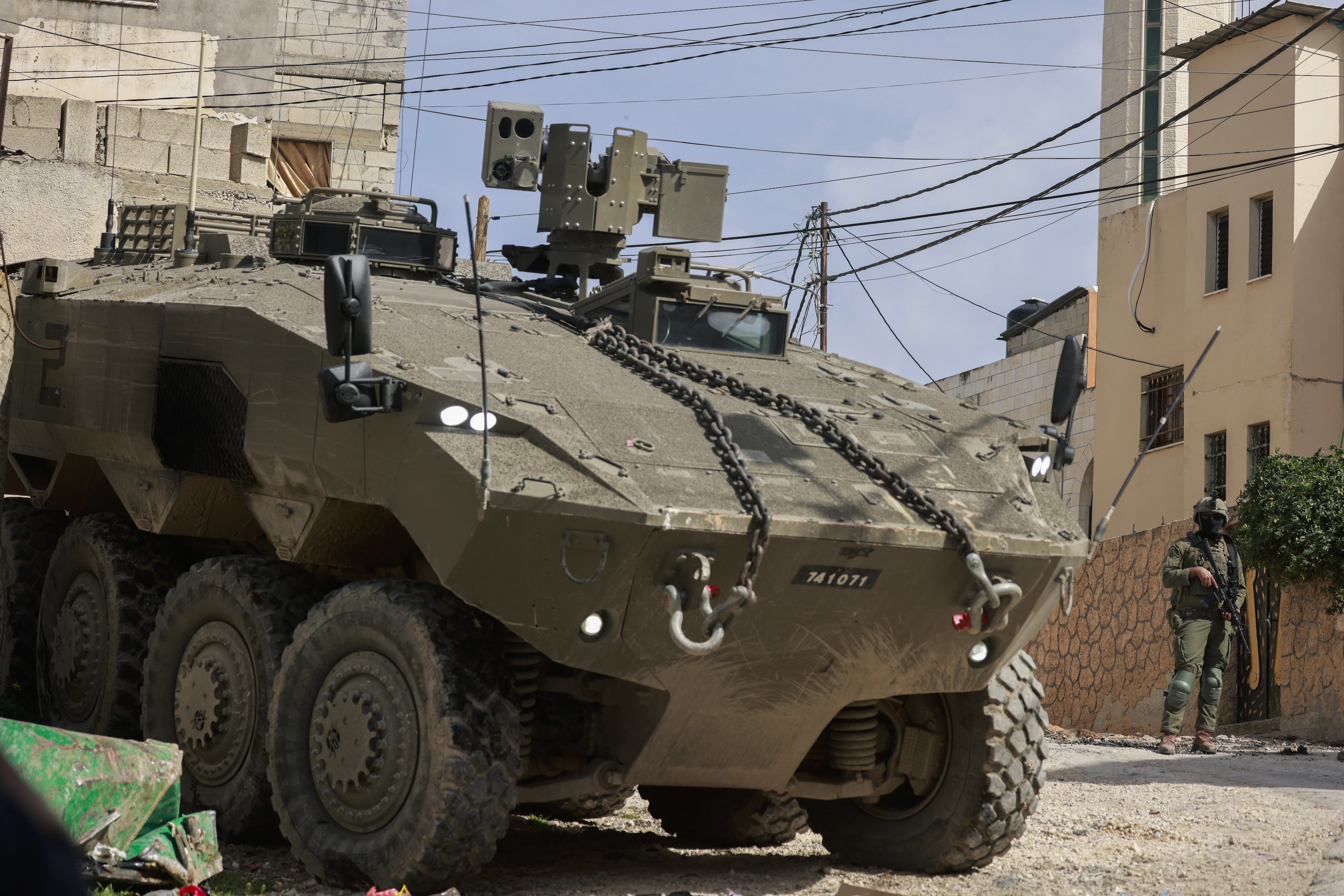 Israeli soldiers stand guar near their armoured vehicles as they conduct a raid in the eastern neighbourhood of Jenin amid a weeks-long offensive in the occupied West Bank, March 4, 2025. (AFP)