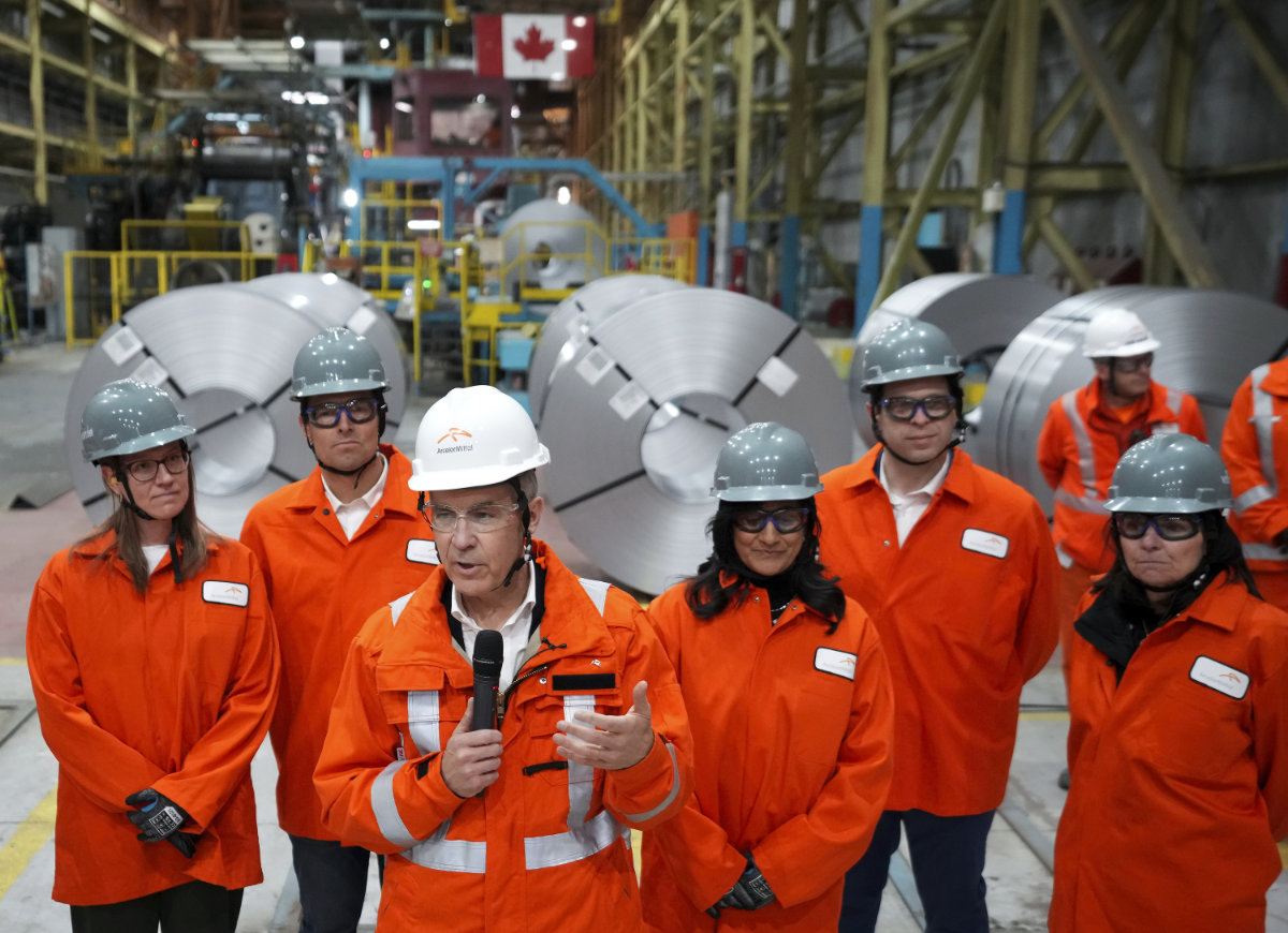 Canadian Prime Minister designate Mark Carney, third left, speaks to steel workers after touring the ArcelorMittal Dofasco steel plant in Hamilton, Ont., on March 12, 2025. (The Canadian Press via AP)