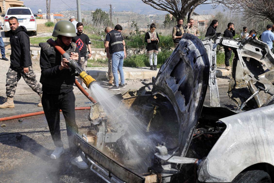 A man douses the flames of a car hit by an Israeli strike in the southern Lebanese village of Burj Al-Muluk on March 15, 2025, in which one person was reportedly killed. (AFP)