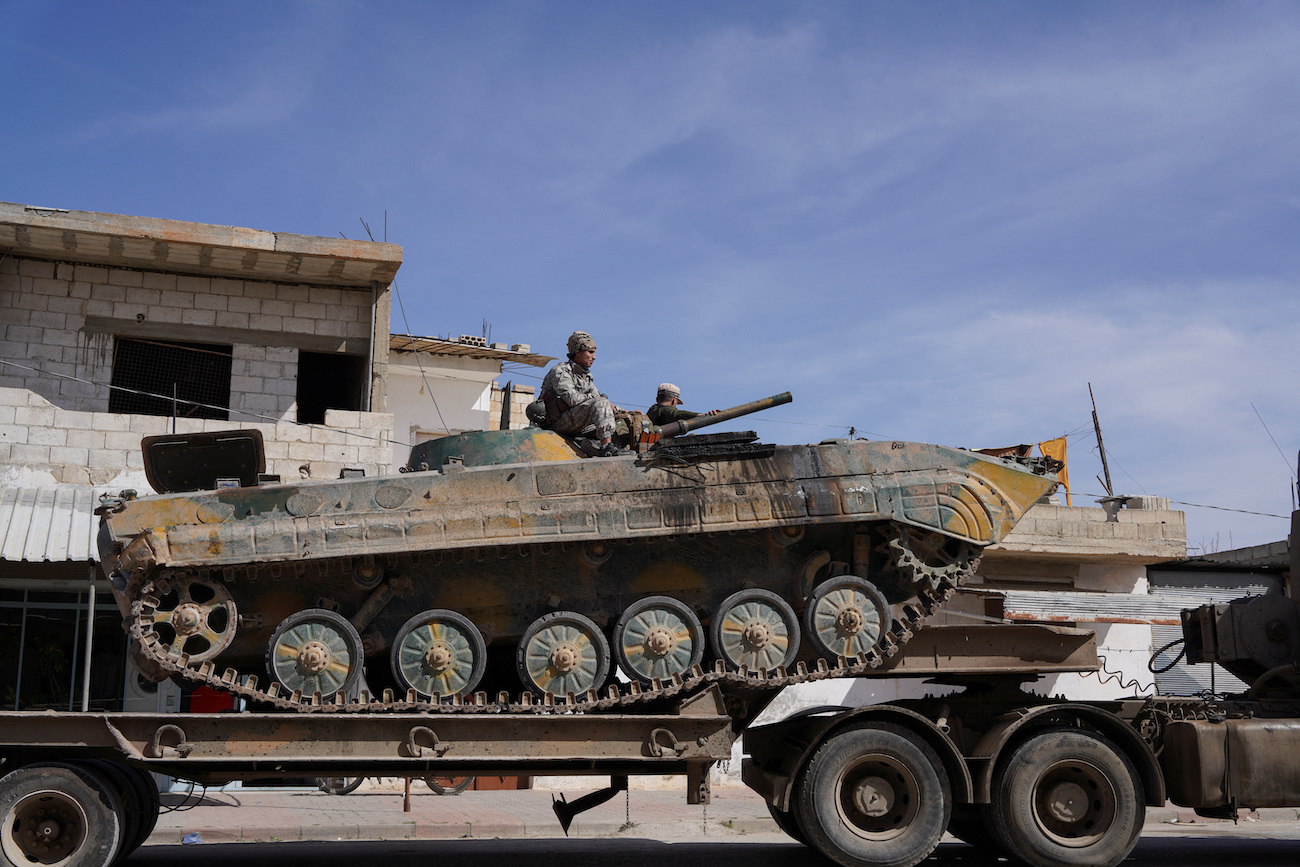 Syrian troops sit atop a military vehicle as they head toward Syrian-Lebanese border following clashes with Lebanese soldiers and armed groups, in Qusayr, Syria, March 17, 2025. (Reuters)