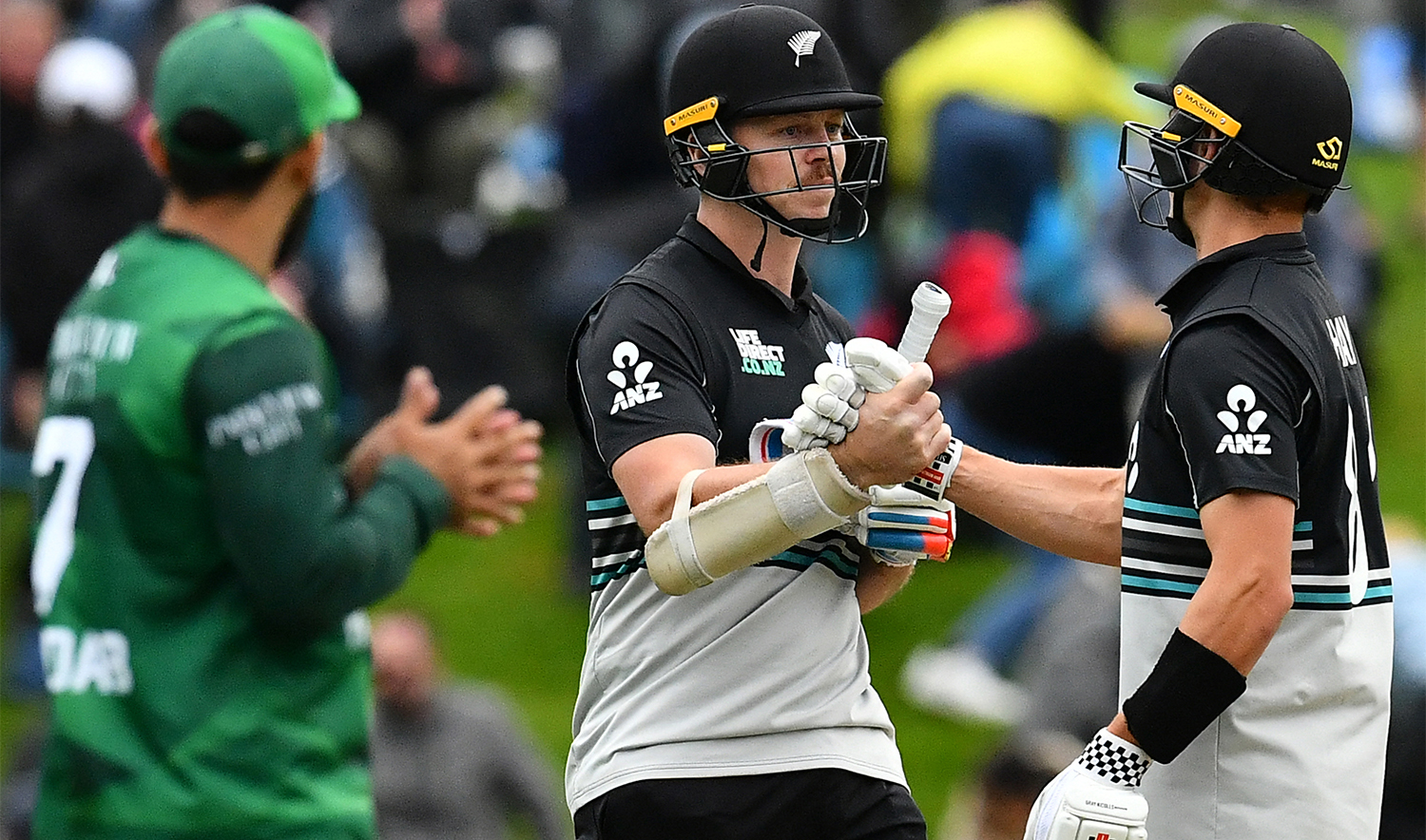 New Zealand's Michael Bracewell (C) and Mitchell Hay (R) celebrate their win in the second Twenty20 international cricket match between New Zealand and Pakistan at University of Otago Oval in Dunedin on March 18, 2025. (