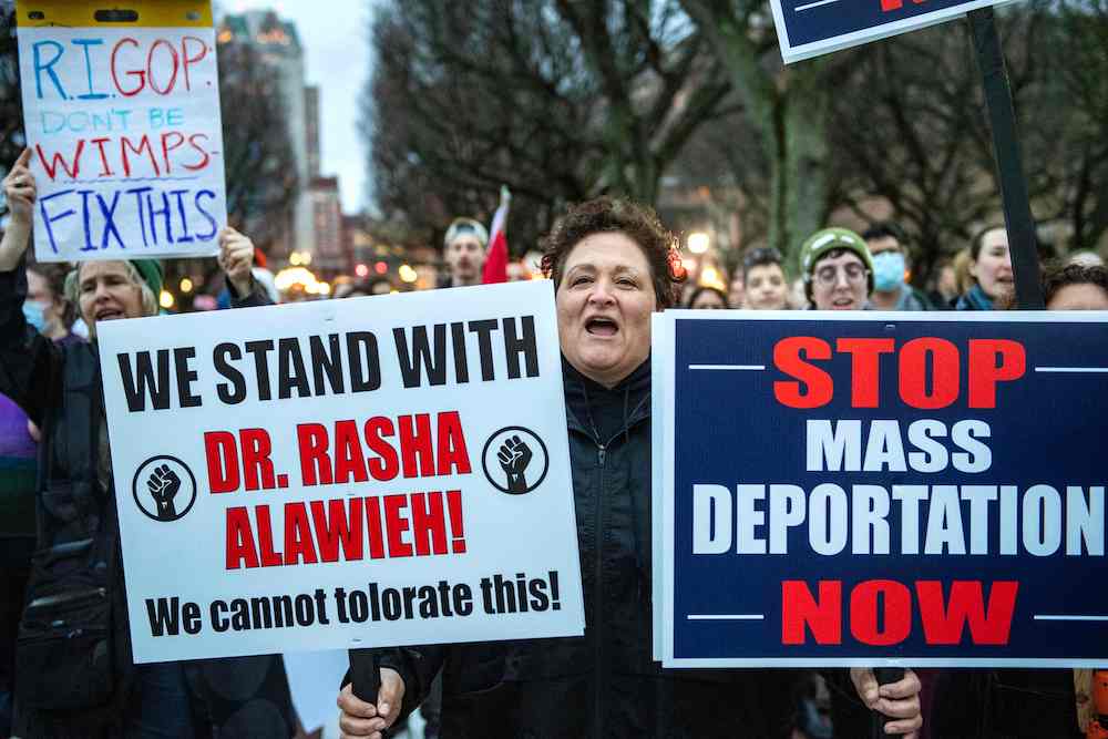 Demonstrators hold signs as they protest the deportation of Assistant Professor of Medicine Dr. Rasha Alawieh of Brown University at the State House in Providence, Rhode Island, on March 17, 2025. ( AFP)