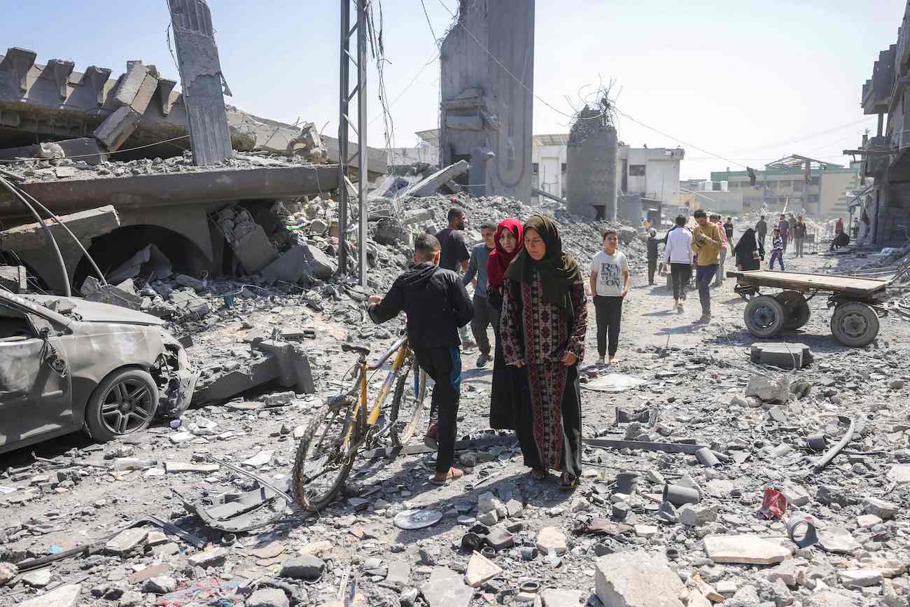 People walk amid the rubble of a building destroyed in an overnight Israeli strike in Jabalia, in the northern Gaza Strip on March 18, 2025. (AFP)