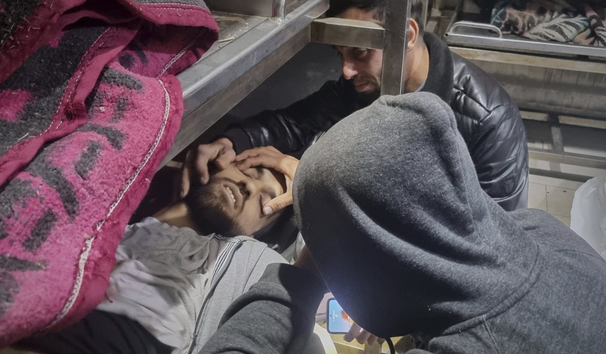 Two people mourn over the body of a man, lying among other victims at the hospital morgue, following Israeli airstrikes in Khan Younis, southern Gaza Strip, Tuesday, March 18, 2025. (AP)
