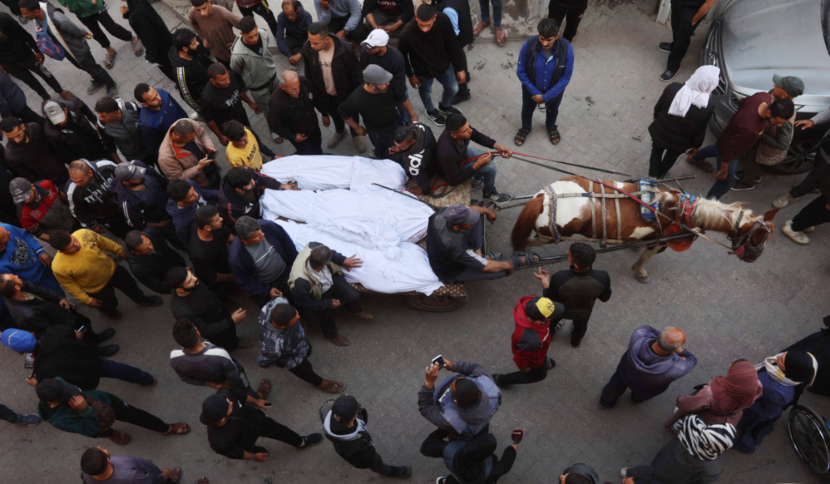 The bodies of victims killed in overnight Israeli airstrikes on the Gaza Strip are carried on a horse cart outside Al-Ahli Arab hospital, also known as the Baptist hospital, in Gaza City ahead of their burial on March 18, 2025. (AFP)