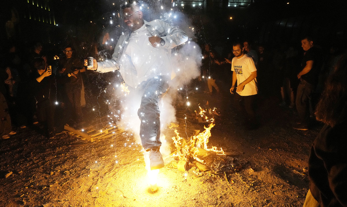 A man in Tehran jumps over a firework celebrating Chaharshanbe Souri, or Wednesday Feast, an ancient festival of fire on the eve of the last Wednesday of the Persian year. (AP)