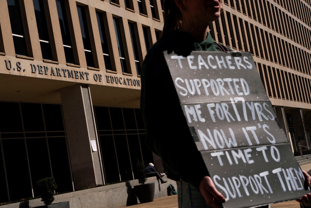 A protester stands near the US Department of Education headquarters. (Reuters/File)