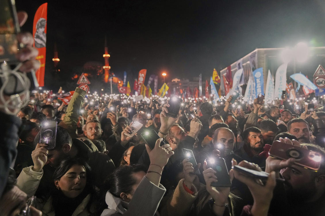 People raise their mobile phones as they gather outside the City Hall to protest the arrest of Istanbul Mayor Ekrem Imamoglu in Istanbul, Turkey, Wednesday, March 19, 2025. (AP)