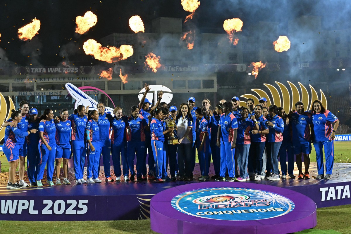 Mumbai Indians’ players along with the team owner Nita Ambani (C) pose with the winning trophy at the end of the Women's Premier League (WPL) Twenty20 final cricket match between Mumbai Indians and Delhi Capitals at Brabourne Stadium in Mumbai on March 16, 2025. (File/AFP)