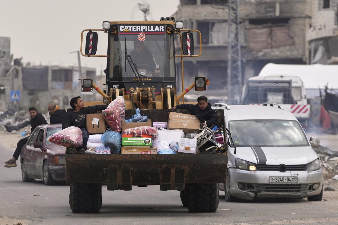 Displaced Palestinians, carrying their belongings, move away from the areas where the Israeli army is operating after Israel’s renewed offensive in the Gaza Strip, in Khan Younis on March 20, 2025. (AP)