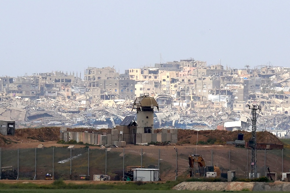 A military watch tower stands along Israel’s southern border with the northern Gaza Strip, backdropped by destroyed buildings on March 20, 2025. (AFP)