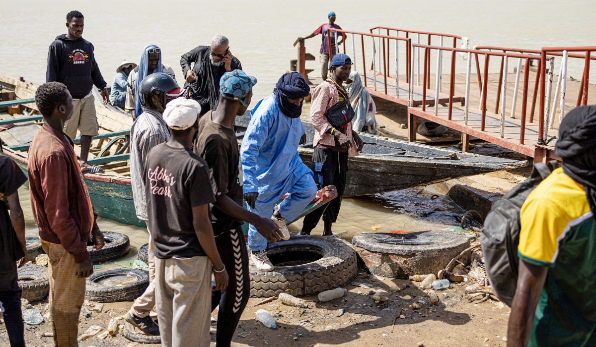 Passengers from the Mauritanian side of the Senegal river disembark from a pirogue in Rosso, Senegal, on March 20, 2025. (AFP)