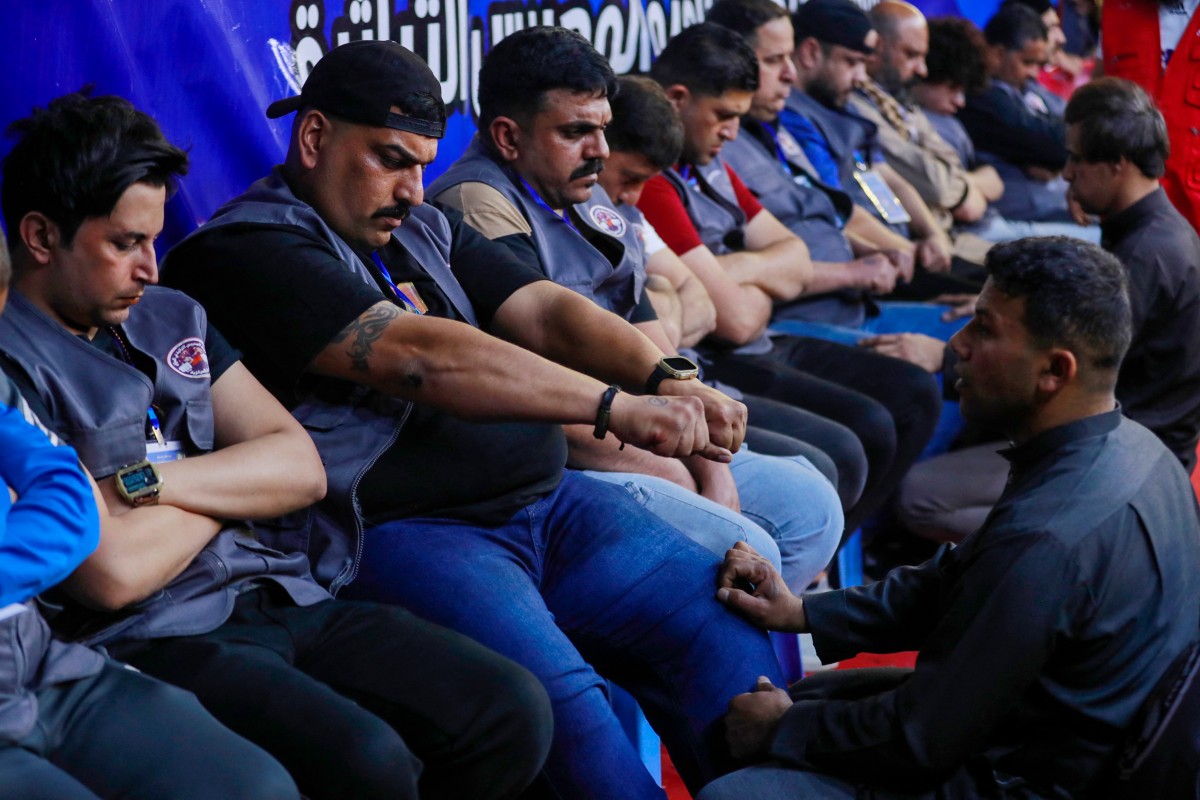 Participants play Mheibes, a decades-old fiery game in which rival teams must find a ring hidden by their oppearly onents, at Al-Shaab Stadium in Baghdad early on March 19, 2025, during the Islamic holy month of Ramadan (AFP)