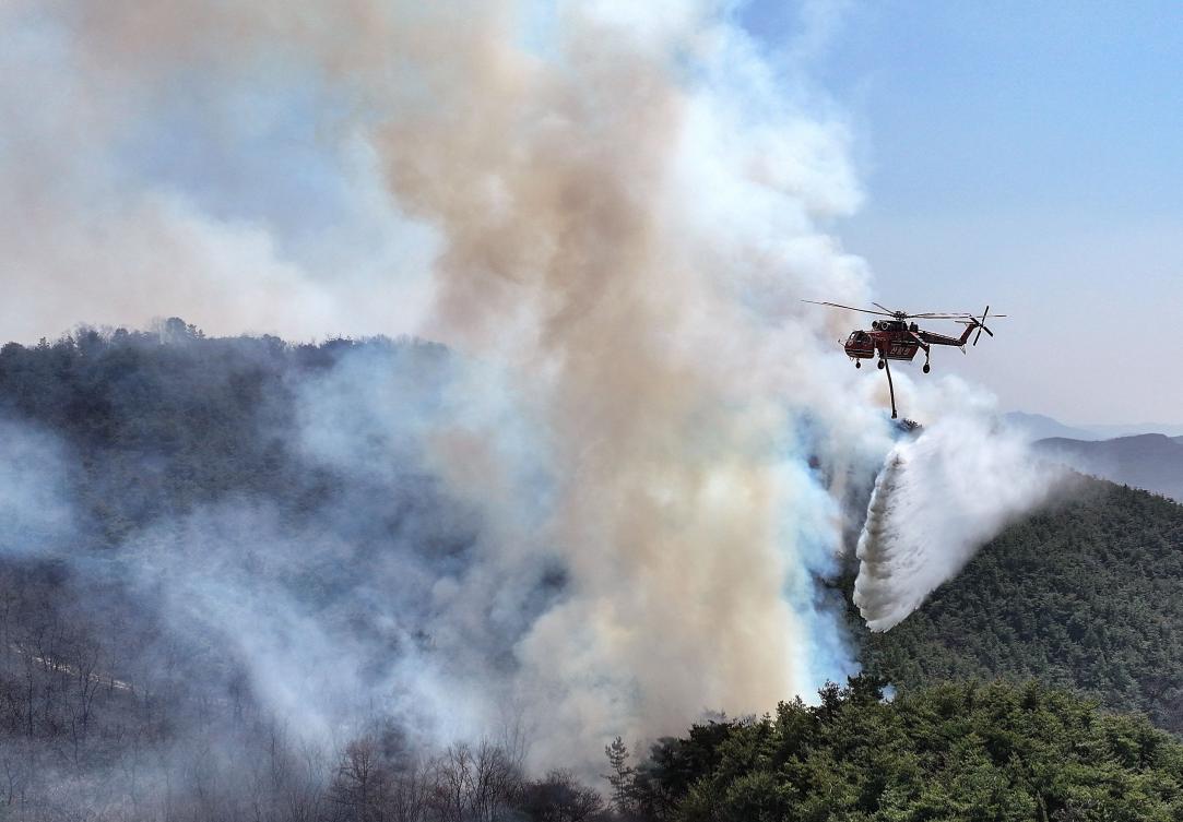 A Korea Forest Service helicopter is used to help extinguish a forest fire near its ignition point in Uiseong, Gyeongbuk on March 23, 2025. (Yonhap/AFP)