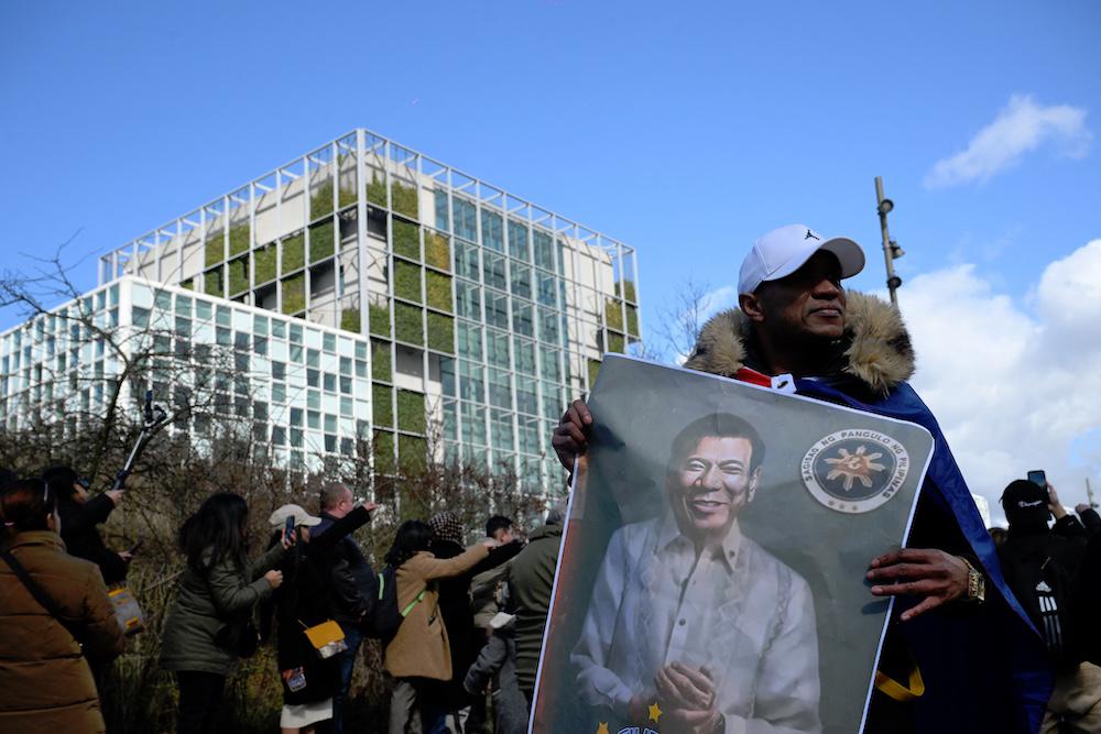 A supporter holds a portrait of former Philippine president Rodrigo Duterte in front of the International Criminal Court in The Hague on March 14, 2025. (AFP)