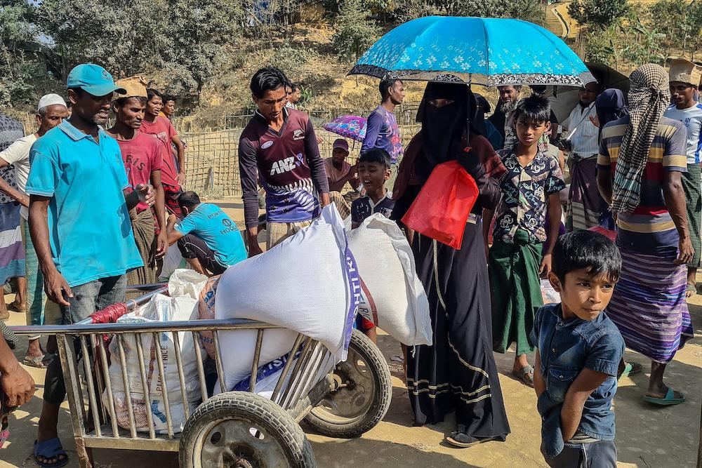 Rohingya refugees gather to collect relief materials from a distribution point in the Kutupalong Refugee Camp in Ukhia in Bangladesh’s Cox’s Bazar district on March 6, 2025. (AFP)