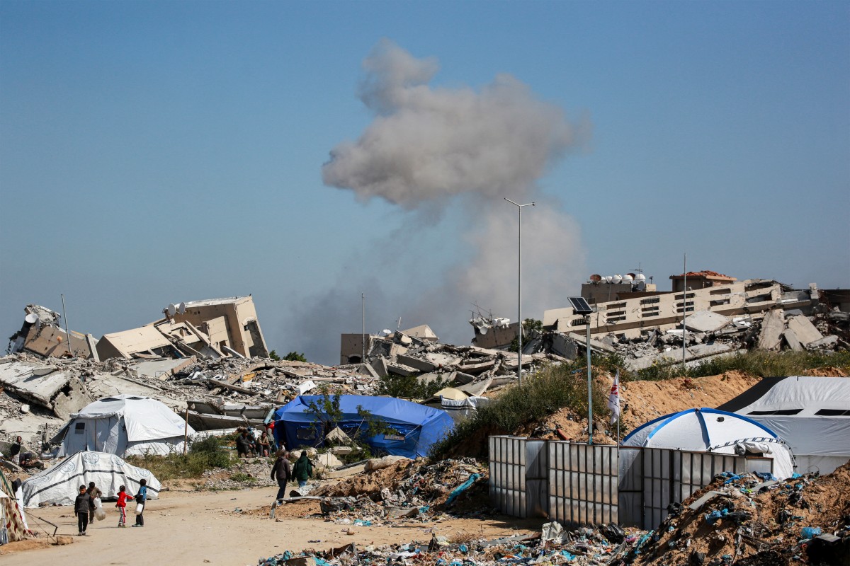 A plume of smoke erupts from a demolition carried out by Israeli forces on a Palestinian building in Beit Lahia in the northern Gaza Strip on March 24, 2025. (AFP)