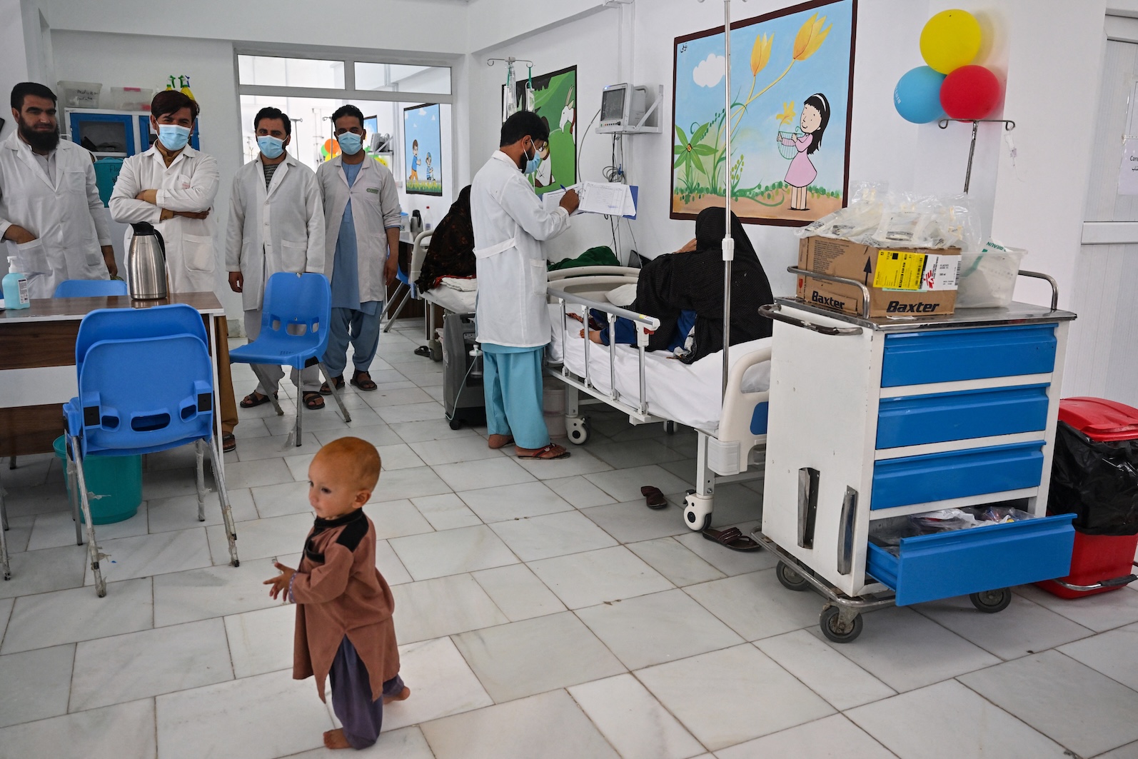 This photo taken on July 21, 2022 shows doctors treating patients in the critical care section of the malnutrition ward at the Boost Hospital, run by Medicines Sans Frontiers, in Lashkar Gah, Helmand. (AFP)