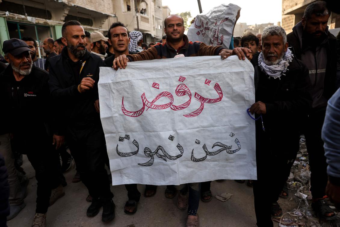 A man carries a sign reading in Arabic: "We refuse to die" during a rally calling for an end to the war, in Beit Lahia, in the northern Gaza Strip, Mar. 25, 2025. (AFP)