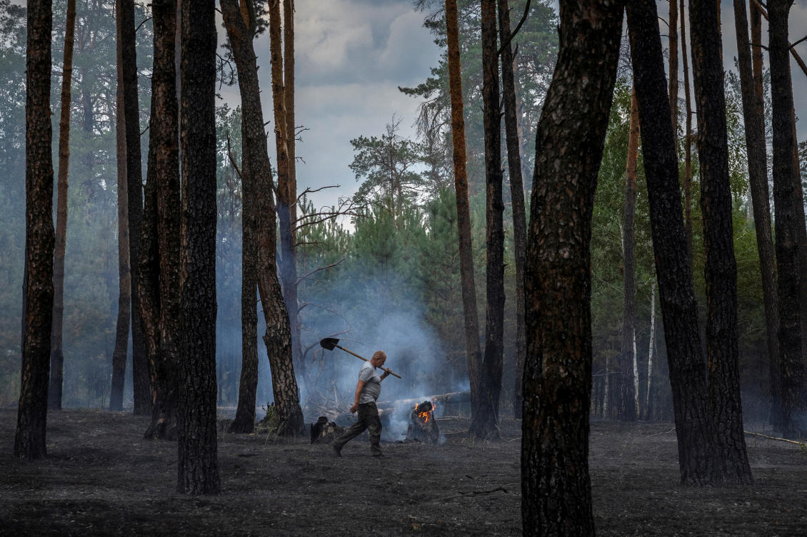 A worker carries a shovel he used to dig a firebreak to contain a forest fire near Yarova, Sviati Hory National Park, Donetsk region, amid Russia’s attack on Ukraine, Jul. 29, 2024. (Reuters/File)