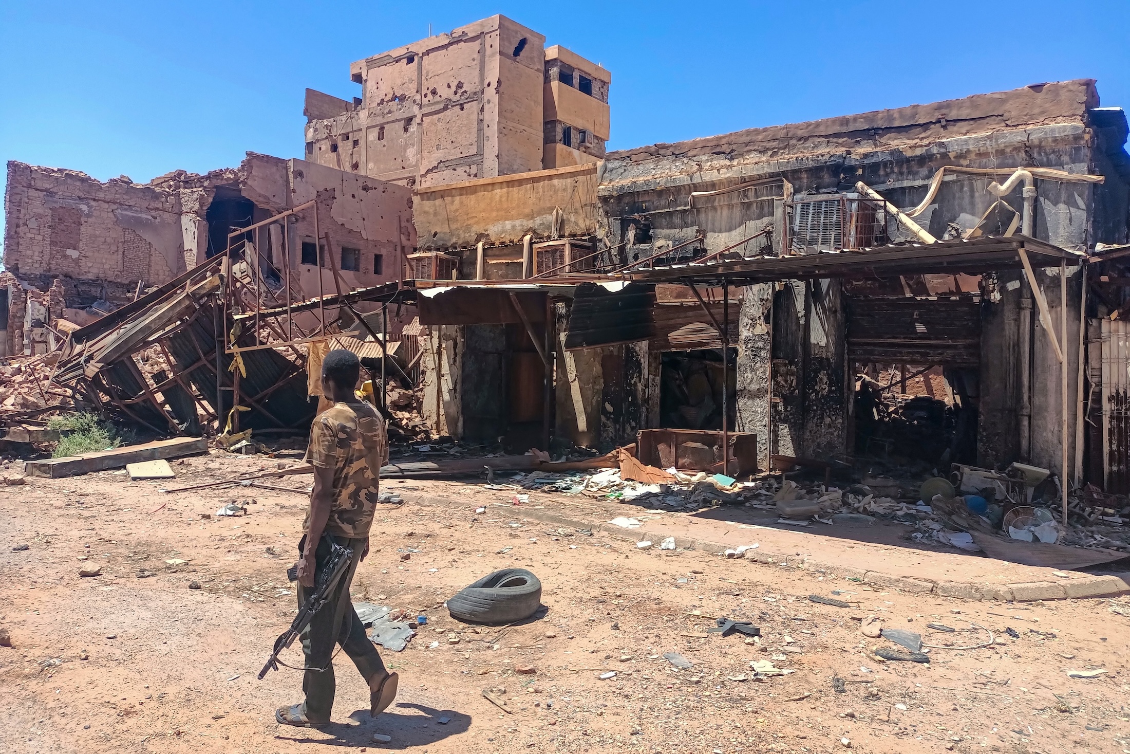 A fighter loyal to the army patrols a market area in Khartoum, Mar. 24, 2025. (AFP)