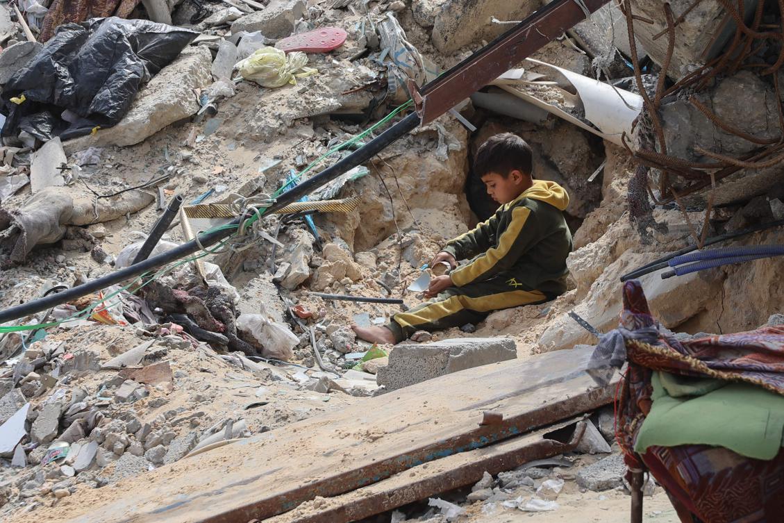 A Palestinian boy plays amidst the debris of a building destroyed during the Israel-Hamas war, in Gaza City on Mar. 28, 2025. (AFP)