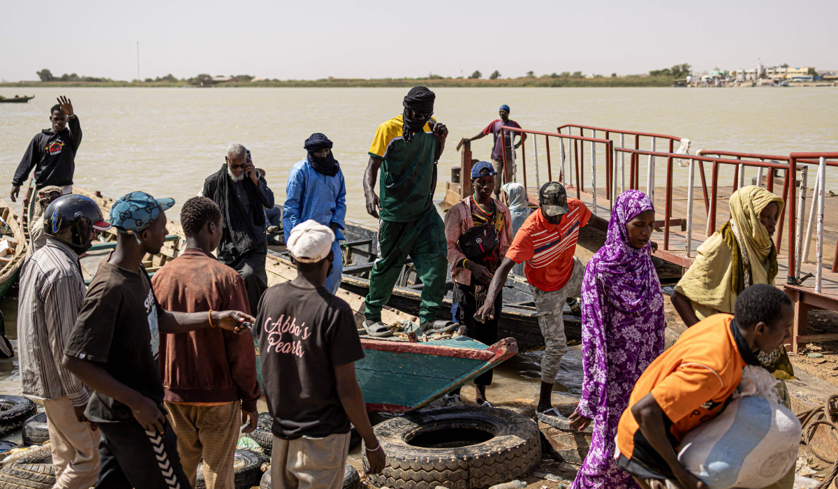 Passengers from the Mauritanian side of the Senegal river disembark from a pirogue in Rosso, Senegal, on March 20, 2025. (AFP)
