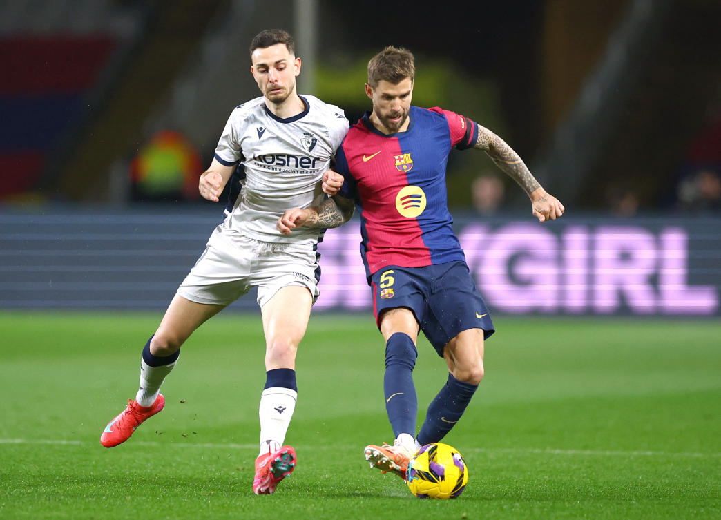 FC Barcelona’s Inigo Martinez in action with Osasuna’s Raul Garcia during their La Liga match at Estadi Olimpic Lluis Companys, Barcelona, Mar. 27, 2025. (Reuters)