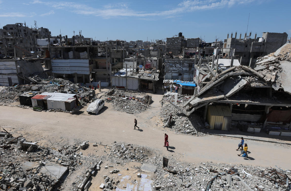 Palestinians walk near rubble of houses in Khan Younis, in the southern Gaza Strip, Mar. 27, 2025. (Reuters)