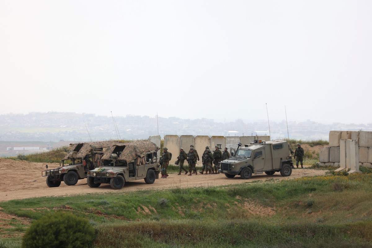Israeli army soldiers walk in a position along Israel's southern border (AFP)