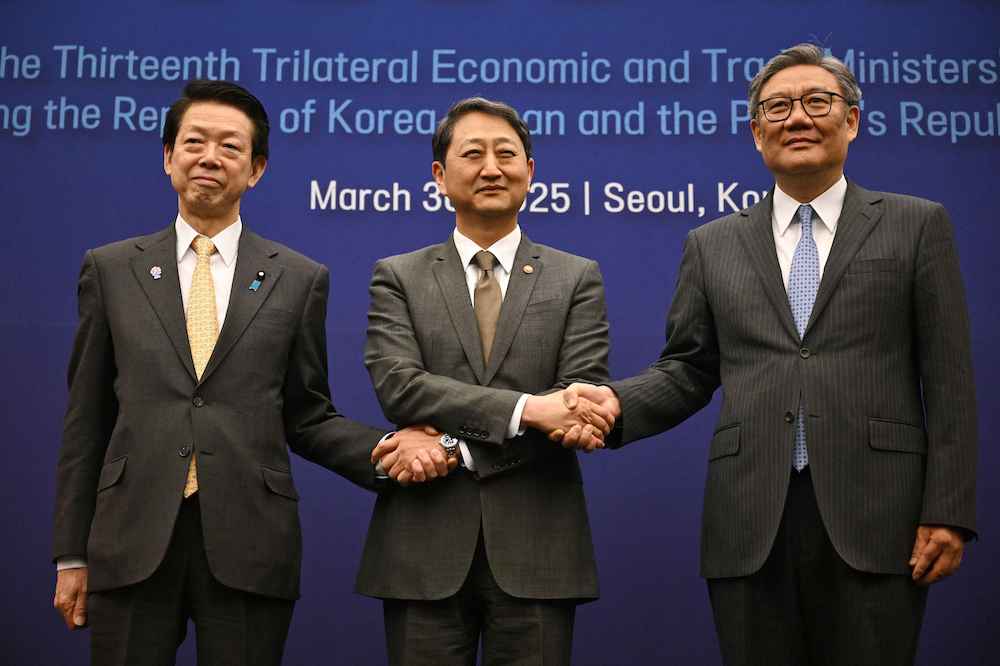 South Korea's Trade, Industry and Energy Minister Ahn Duk-geun, center, poses for a photo with Japan's Economy, Trade and Industry Minister Yoji Muto, left, and China's Commerce Minister Wang Wentao, right, during a meeting in Seoul on March 30, 2025. (AFP)