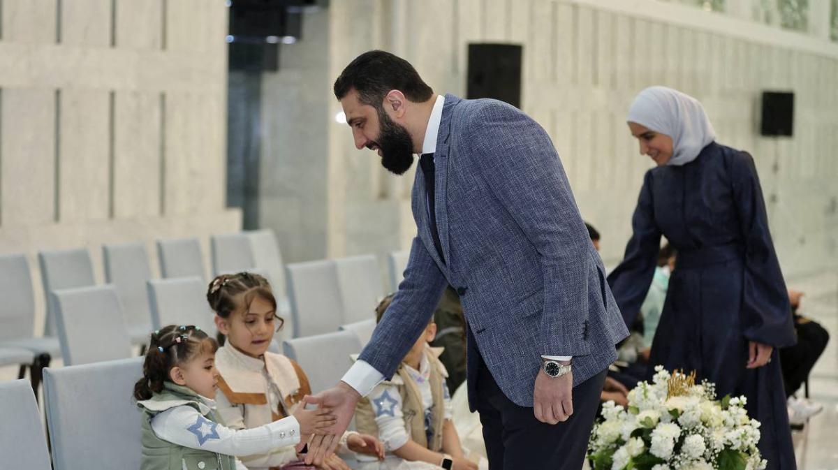 President Ahmed Al-Sharaa and First Lady Latifa Al-Daroubi greeting Syrian children, who lost their parents during the war, at the People's Palace in Damascus on March 31, 2025, on the first day of Eid al-Fitr marking the end of the holy Muslim month of Ramadan. (AFP)