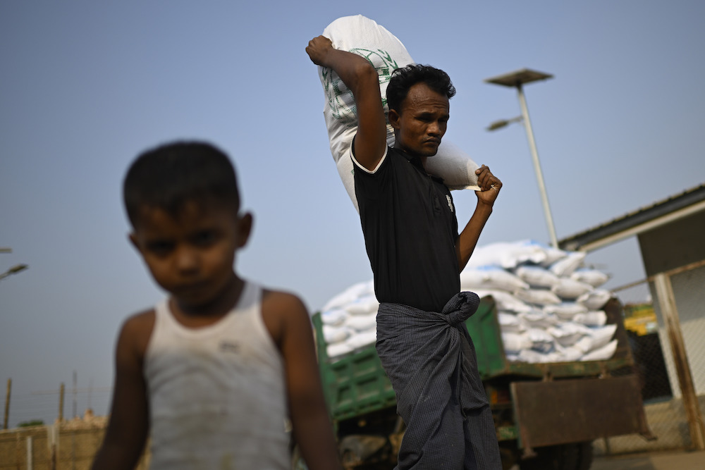 Rohingya refugee carries a food ration sack on his back from a distribution center in Cox's Bazar. (AP)