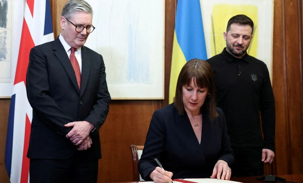 Rachel Reeves signs the UK-Ukraine Bilateral agreement as Keir Starmer and Volodymyr Zelensky look on, Mar. 1, 2025. (Reuters)