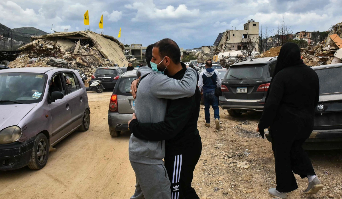 People embrace as they return to their homes in the southern Lebanese village of Kfar Kila near the border with Israel on February 19, 2025. (AFP)