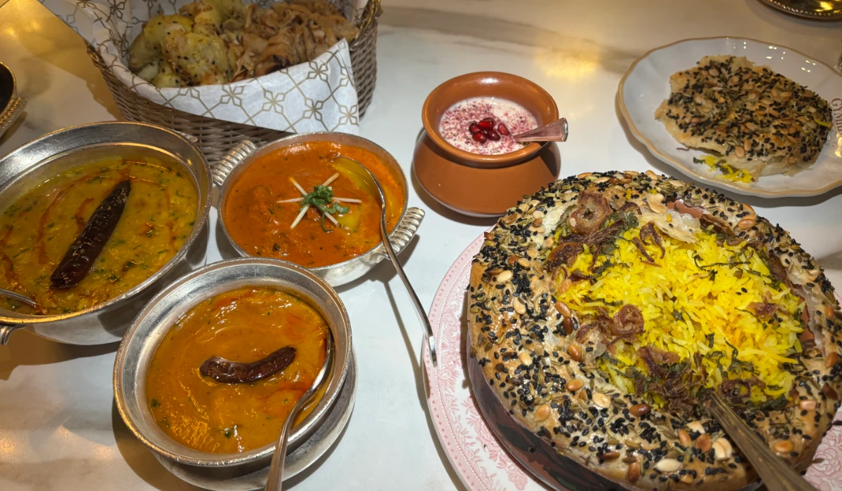 The iftar main course features dum lamb biryani with a flaky, seeded crust, accompanied by dal lasooni, chicken butter masala, and goan prawn curry, served alongside freshly baked bread and cooling raita. (AN photo by Waad Hussain)