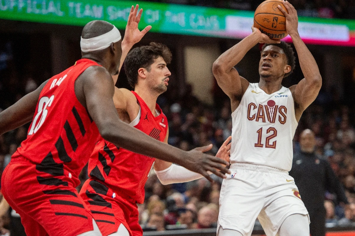 Cleveland Cavaliers’ De’Andre Hunter (shoots as Portland Trail Blazers’ Duop Reath, front, and Deni Avdija, rear, defend during the second half of an NBA basketball game in Cleveland Sunday. (AP)