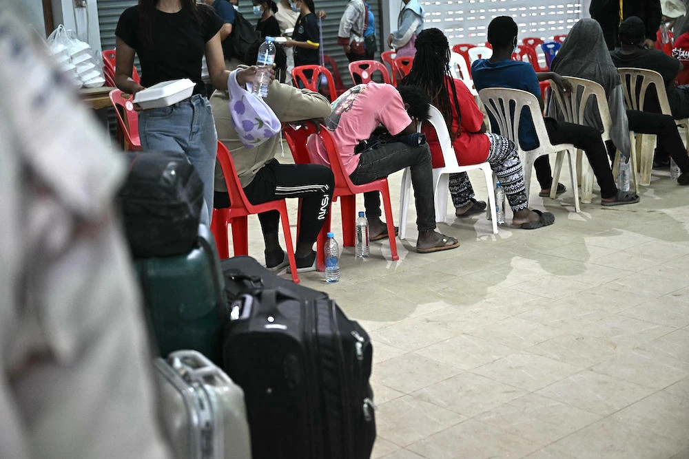 Above, alleged victims of scam centers in Myanmar are processed at Phra district of Tak province in Thailand on Feb. 12, 2025. (AFP)