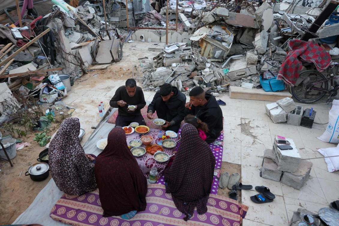 Doctor Khaled Mohammed Abu Jari, 57, (C-L) head of the critical care department at the Beit Hanoun Hospital has iftar with his family outside their tent in Beit Lahia in northern Gaza Strip during Ramadan. (AFP)