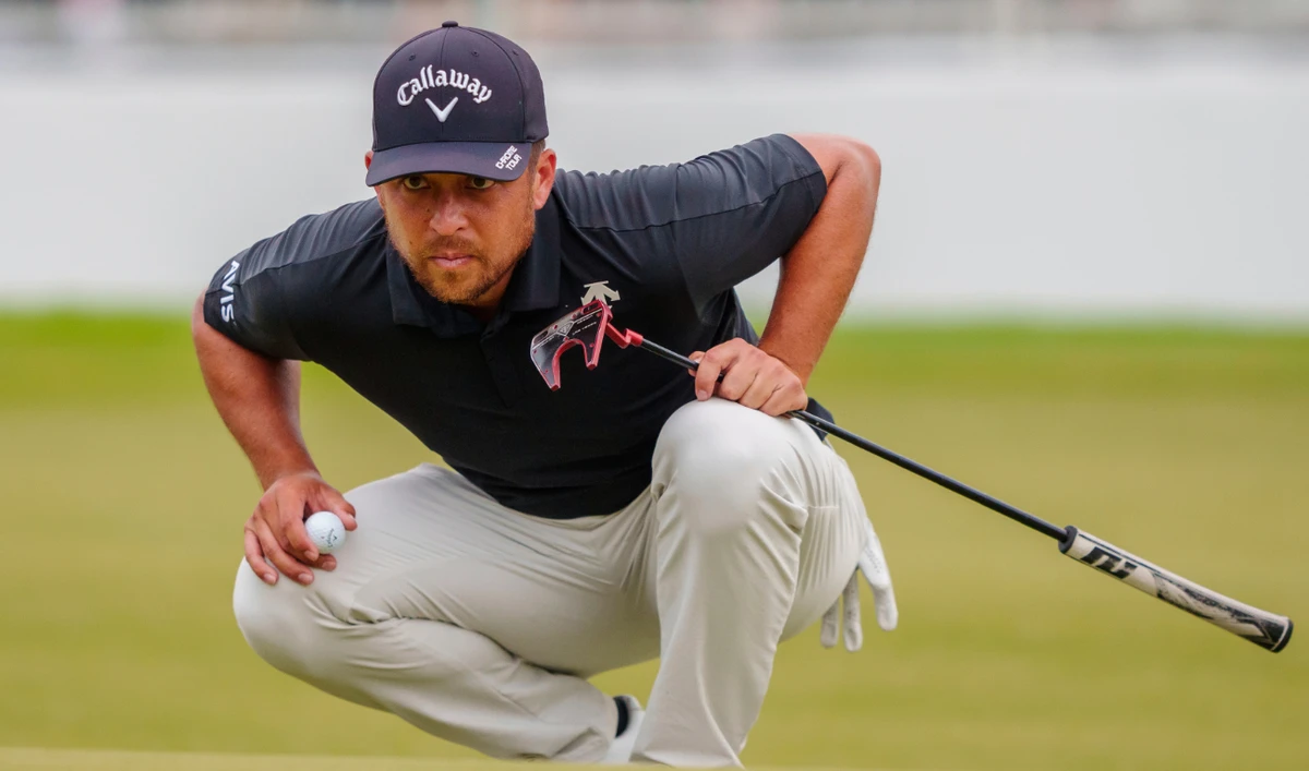 Xander Schauffele checks his line before putting on the 18th green during the third round of the Tour Championship golf tournament on Aug. 31, 2024, in Atlanta. (File/AP)