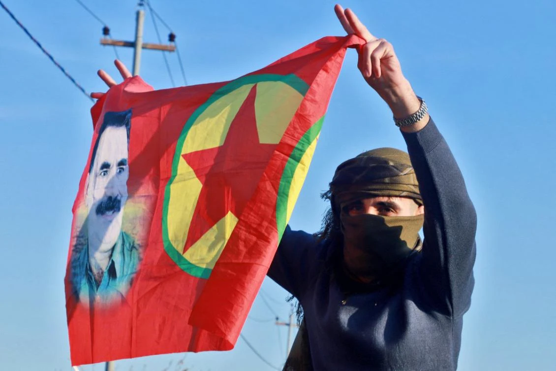 An Iraqi Kurdish woman waves a flag bearing the portrait of the founder of the Kurdistan Worker's Party (PKK) Abdullah Ocalan as people gather at Freedom Park to listen to an audio message by the jailed leader in Sulaimaniyah, in Iraq's autonomous Kurdistan region on February 27, 2025. (AFP)