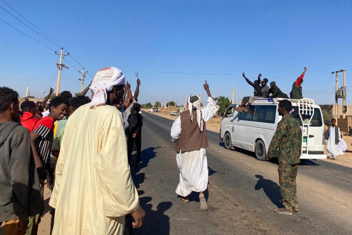 Sudanese people celebrate with passengers of passing vehicles in Meroe in the country's Northern State on January 11, 2025, after the army announced entering key Al-Jazira state capital Wad Madani, held by the paramilitary Rapid Support Forces (RSF). (File/AFP)