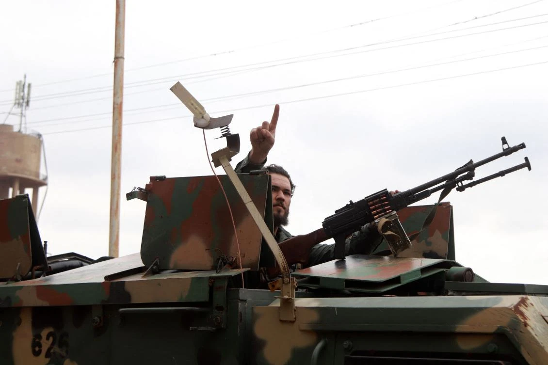 A member of Syria's new authorities security forces gestures from an armoured vehicle in Sanamayn, in the southern province of Daraa, during a reported large scale military campaign on March 5, 2025. (AFP)