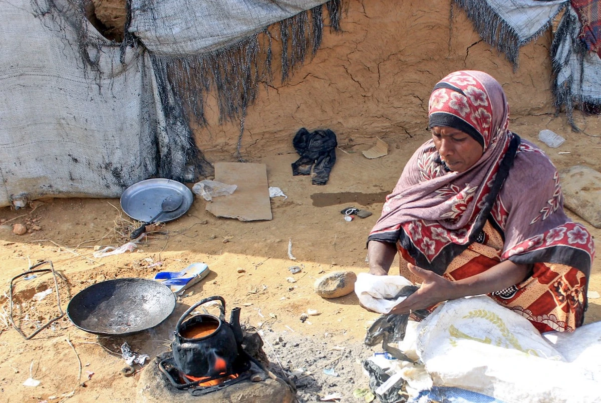 A Yemeni woman cooks on an outdoor clay stove at a makeshift camp in the northern Hajjah province. (File/AFP)