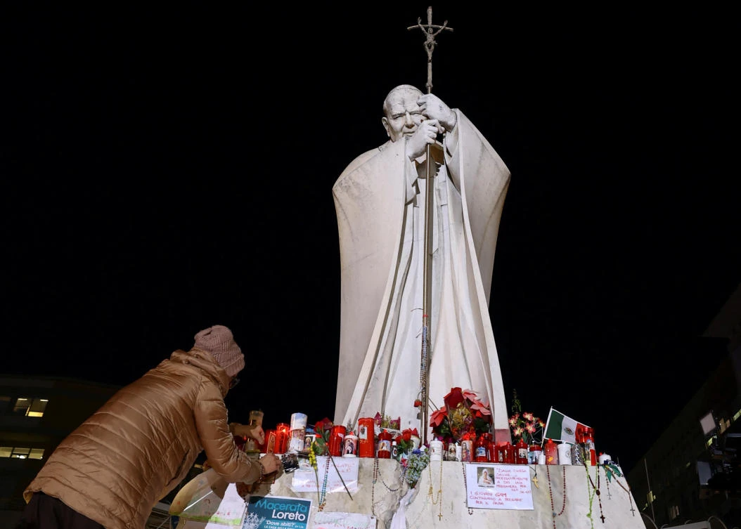 Candles are placed at the statue of late Pope John Paul II outside Gemelli Hospital where Pope Francis is admitted for treatment, in Rome, Mar. 6, 2025. (Reuters)