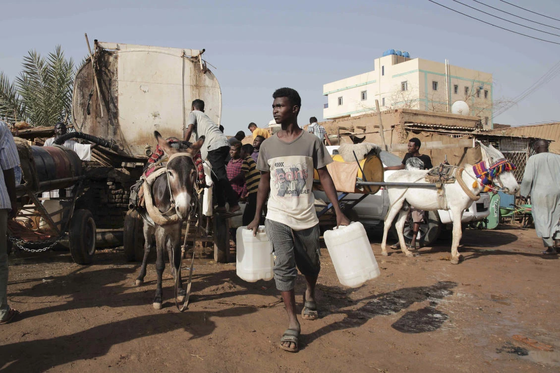 The freed Egyptian captives had been working in Khartoum for years importing household goods and small electric appliances. Above, people gather to collect water in Khartoum. (AP)