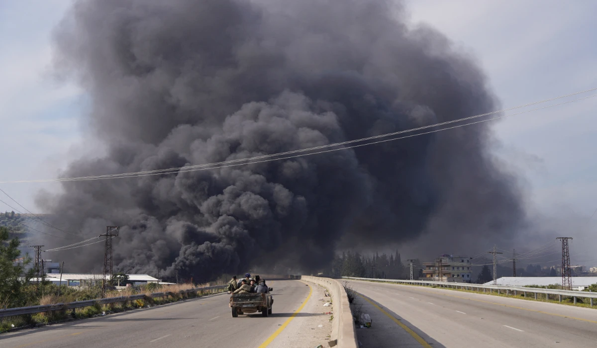 Smoke rises while members of the Syrian forces ride on a vehicle as they battle against a nascent insurgency by fighters from ousted leader Bashar al-Assad's Alawite sect, in Latakia, Syria March 7, 2025. (REUTERS)