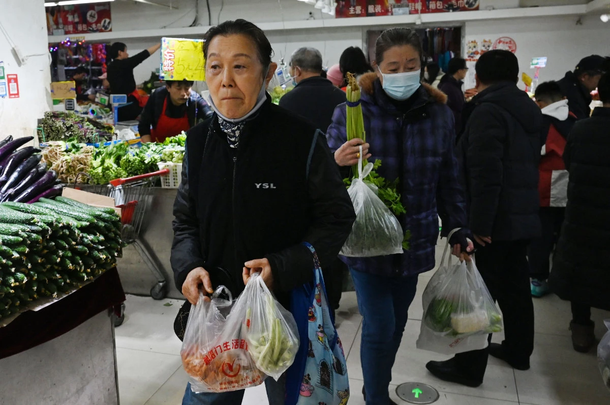 People shop for vegetables in a market in Beijing on March 9, 2025. Consumer prices in China fell last month, with authorities struggling to kickstart spending and trade headwinds intensifying as US tariffs kick in under Donald Trump. (AFP)